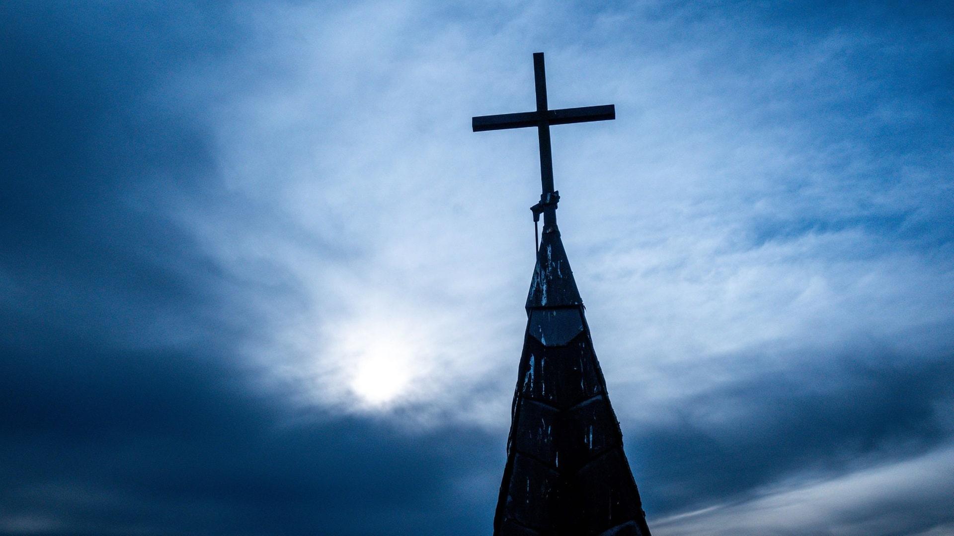 Ein Kirchenkreuz auf dem Dach der entwidmeten ehemaligen katholischen Kirche Mariä Geburt  | picture-alliance / Reportdienste, picture alliance/dpa | Jens Büttner