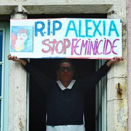 Eine Frau hält ein Schild mit der Aufschrift RIP Alexia in die Höhe