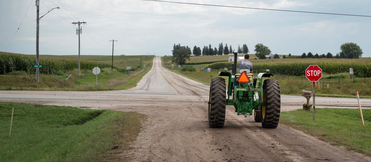 Ein Traktor steht an einer Kreuzung auf einer Farm in Iowa, USA.