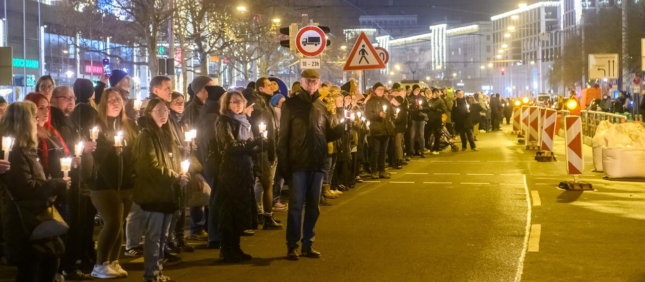 Menschen bilden eine Lichterkette in Magdeburg