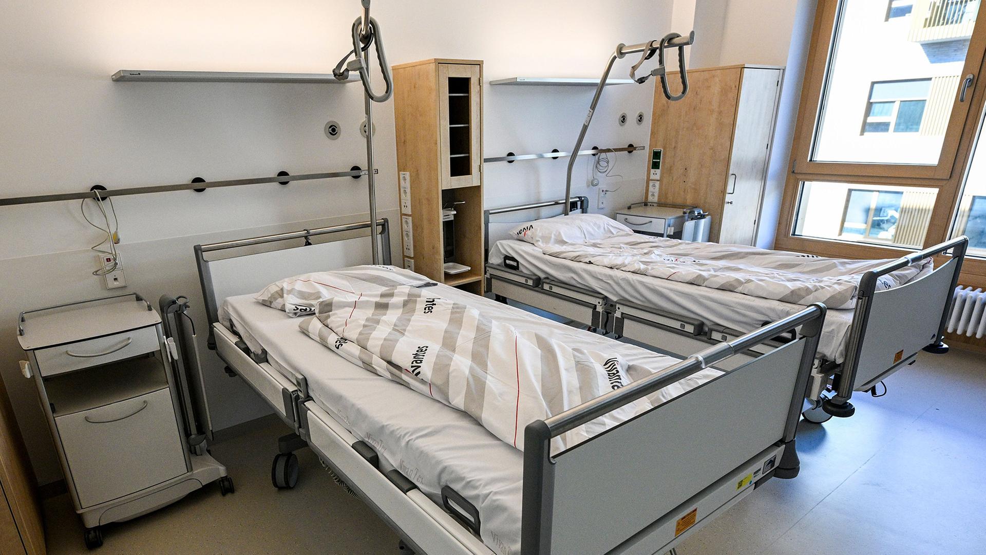 Betten stehen in einem Krankenhauszimmer. | Jens Kalaene/dpa