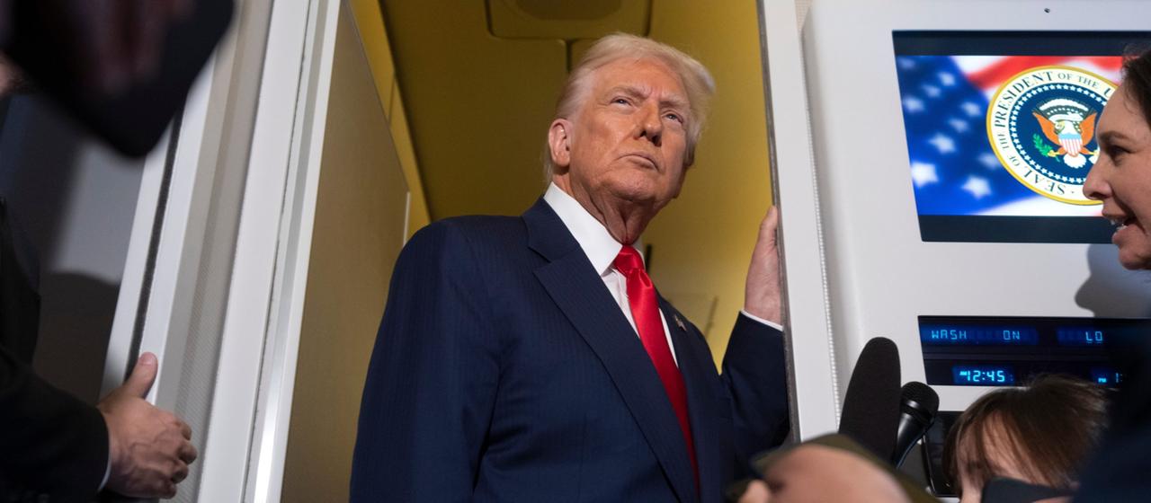 Donald Trump spricht an Bord der Air Force One mit Reportern.
