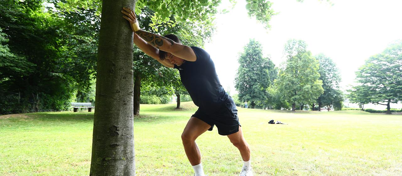 Ein Mann dehnt sich beim Outdoor-Training.