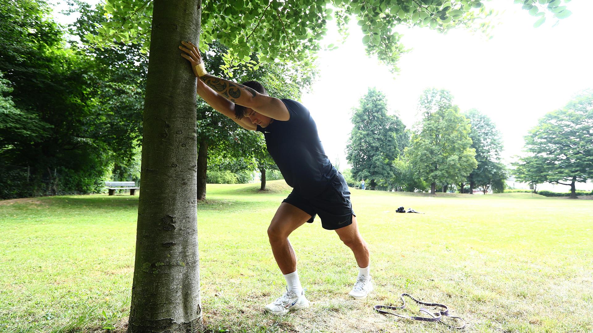 Ein Mann dehnt sich beim Outdoor-Training.