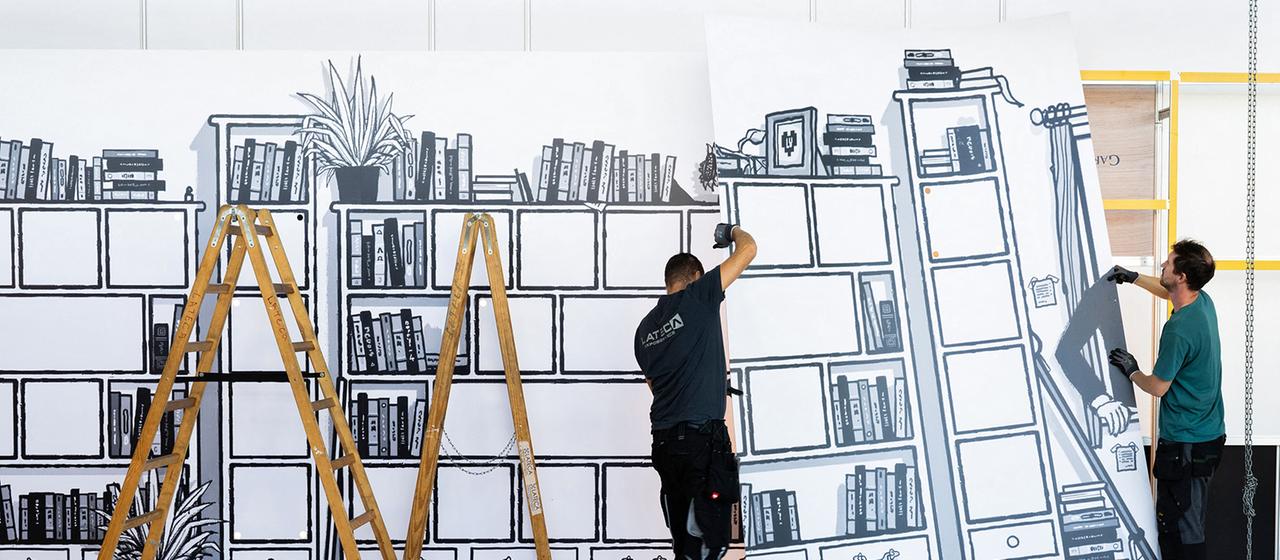 Messebauer errichten den Stand eines Buchverlages auf der Frankfurter Buchmesse.