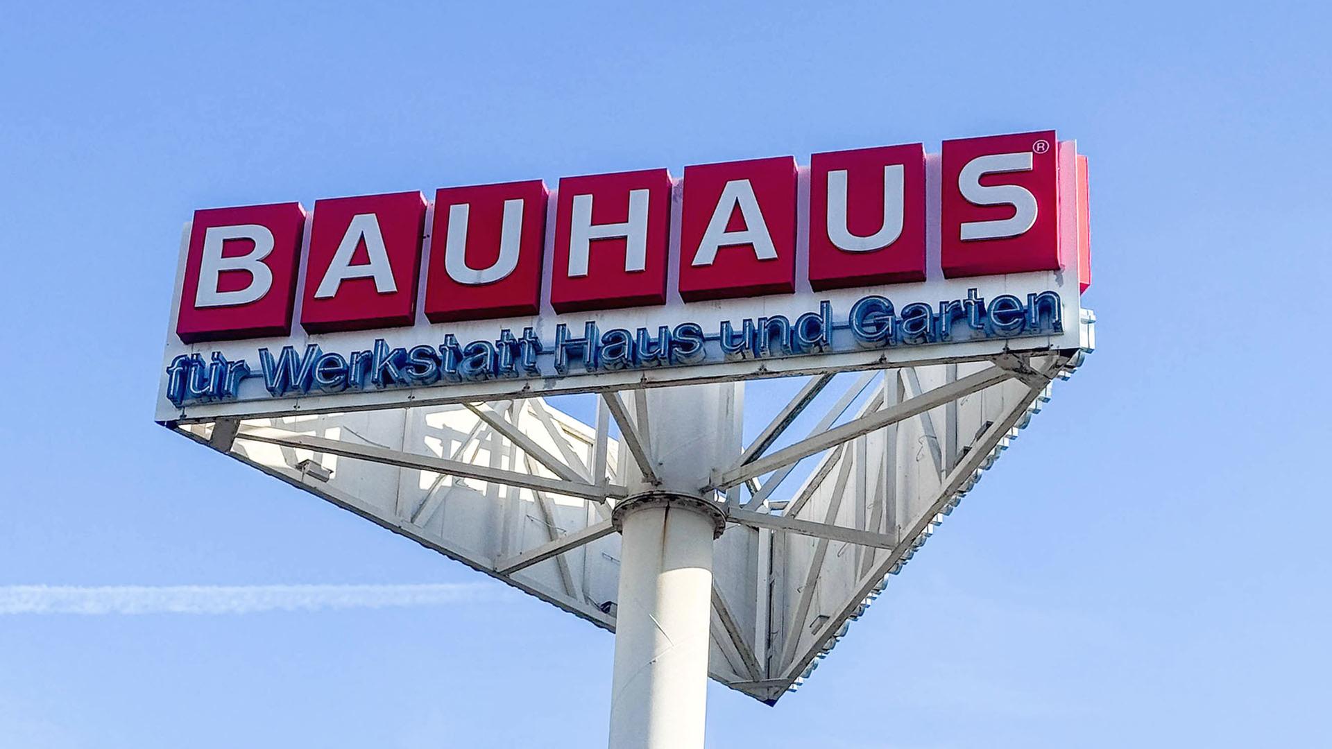 Großes BAUHAUS-Werbeschild mit dem Schriftzug für Werkstatt Haus und Garten vor blauem Himmel. (Quelle: imago images/Luka) | imago images/Luka