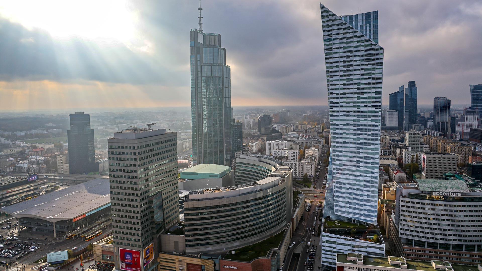 Die Sonne scheint bei wechselhafter Bewölkung auf die Wolkenkratzer in der Innenstadt von Warschau. | picture alliance/dpa