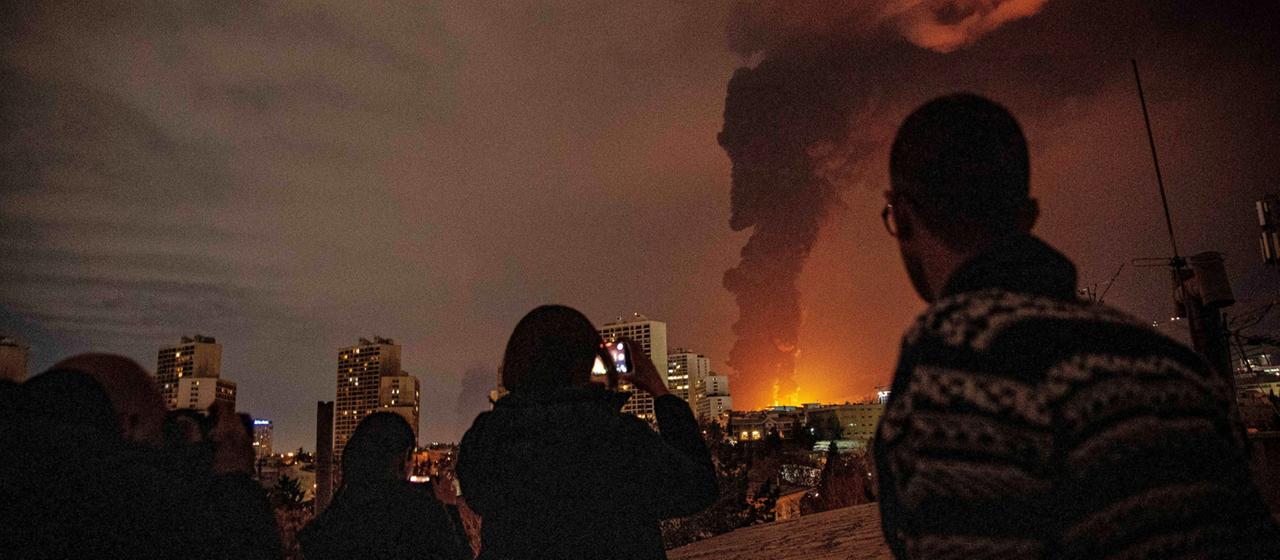 Menschen in Teheran machen Fotos von einer riesigen Rauchsäule, die von einem brennenden Öllager ausgehen soll.