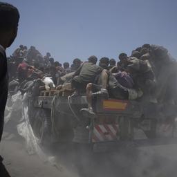 Bewohner des Gazastreifens halten sich an einem Lastwagen mit Hilfsgütern fest.