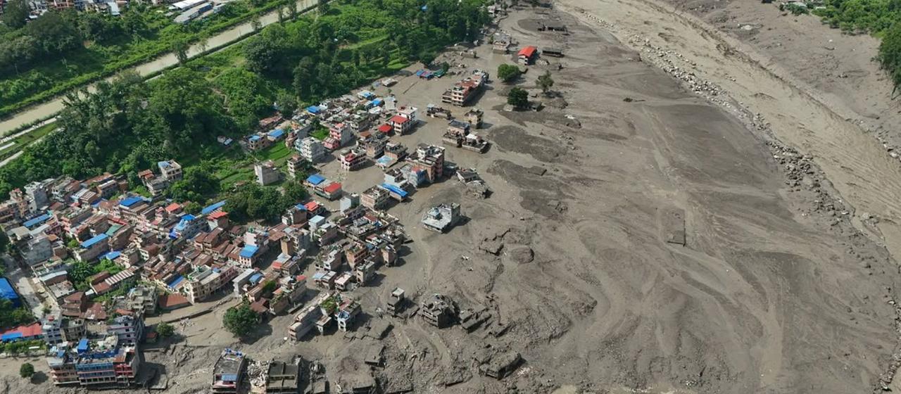 Nach Sturzfluten im nepalesischen Distrikt Nuwakot stehen beschädigte Häuser gefährlich nahe an den angeschwollenen, mit Treibgut verstopften Ufern des Trishuli-Flusses.