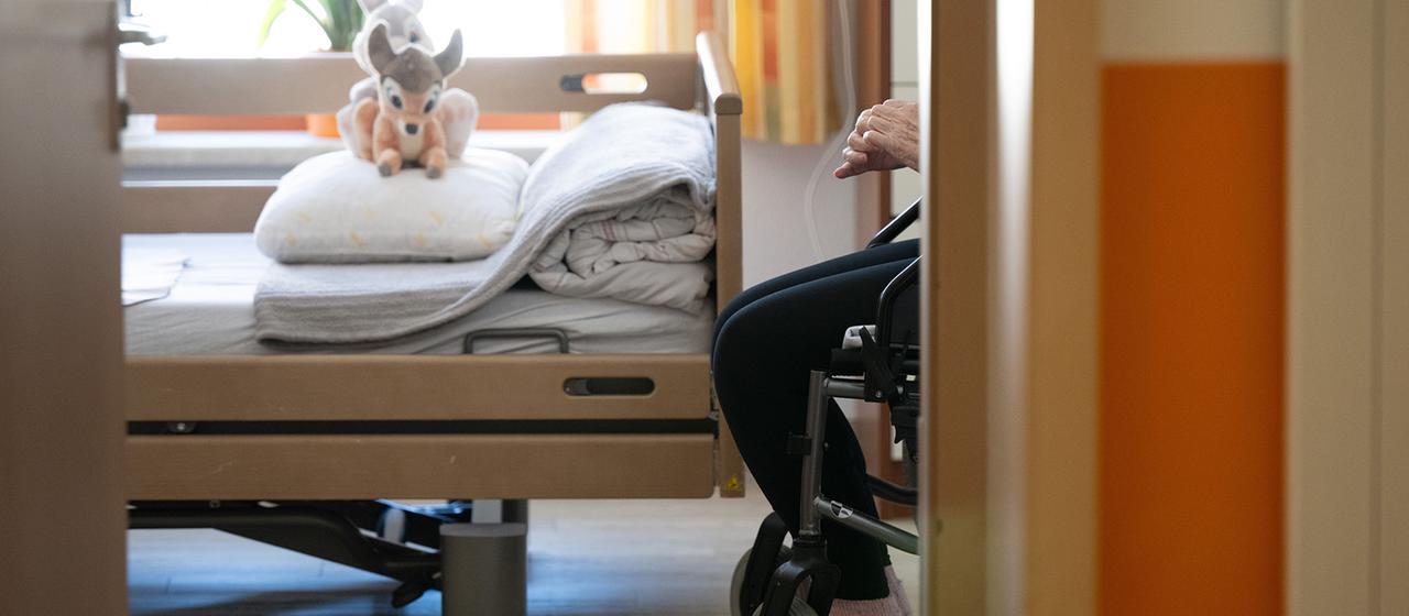 Ein Bewohner sitzt in einem Altenheim in seinem Zimmer in einem Rollstuhl.