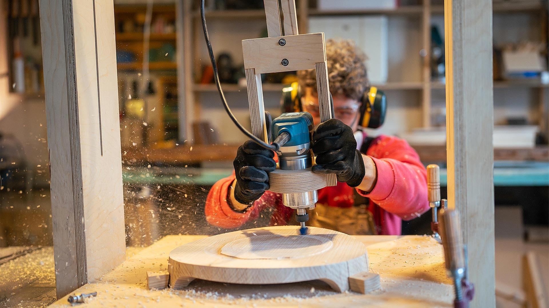 Handwerker bearbeitet Holz mit einer Fräse. | picture alliance / Zoonar