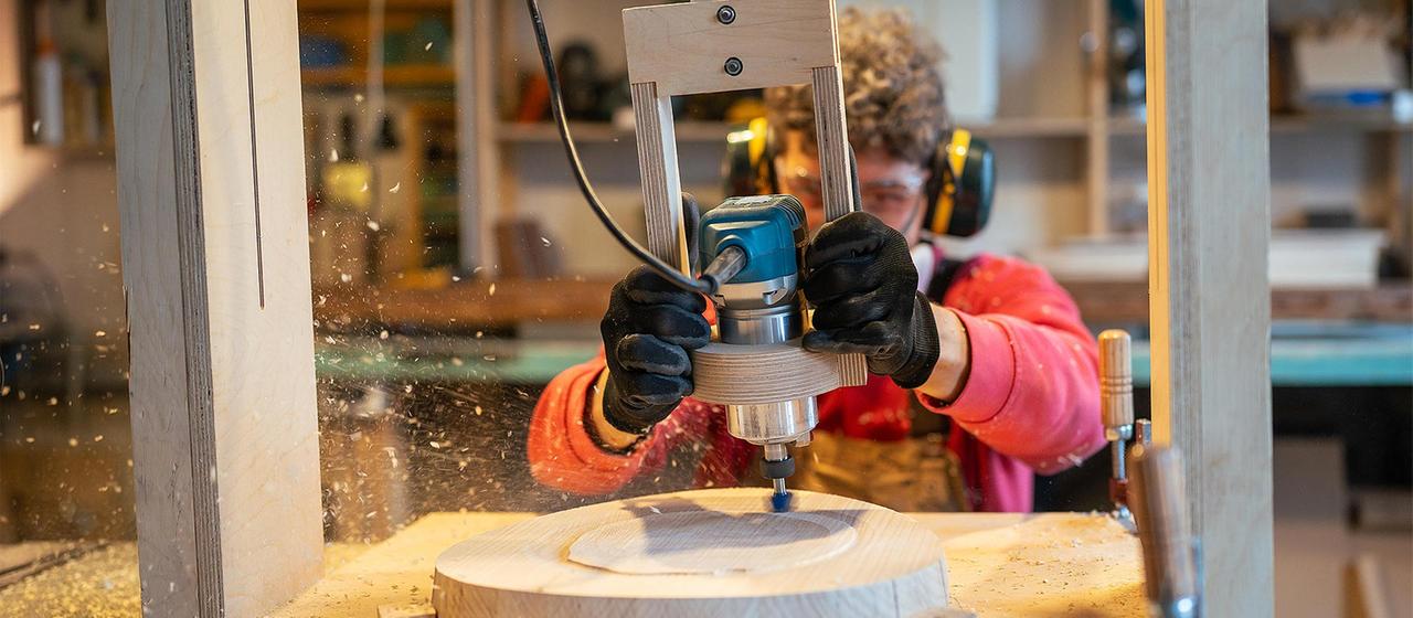 Handwerker bearbeitet Holz mit einer Fräse.