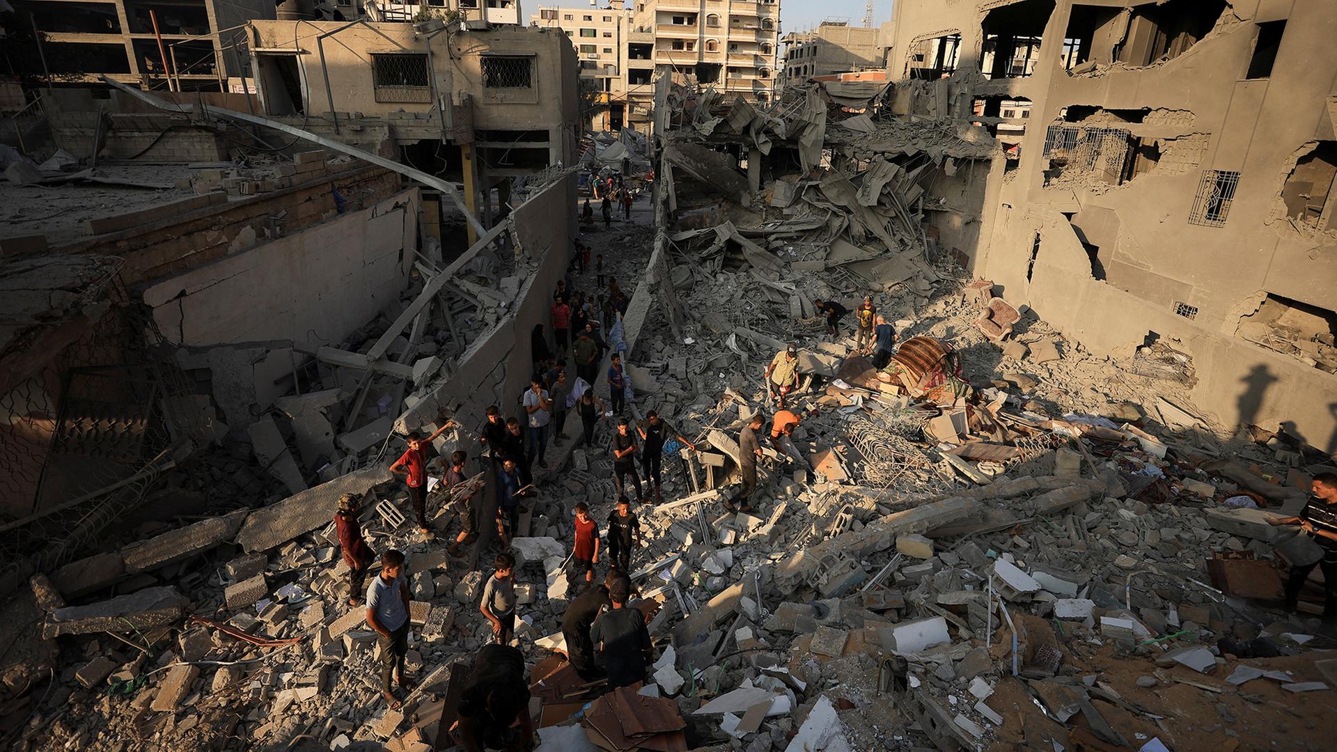 Menschen betrachten die Trümmer eines zerstörten Hauses in Gaza-Stadt. | REUTERS