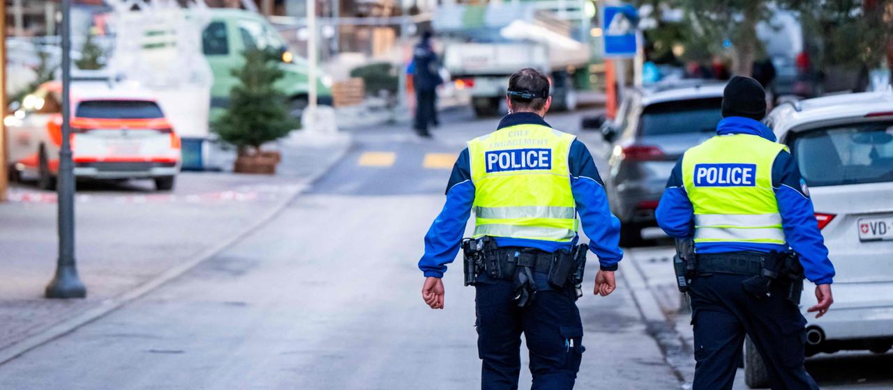 Zwei Polizisten laufen durch eine Straße im Schweizer Skiort Crans-Montana