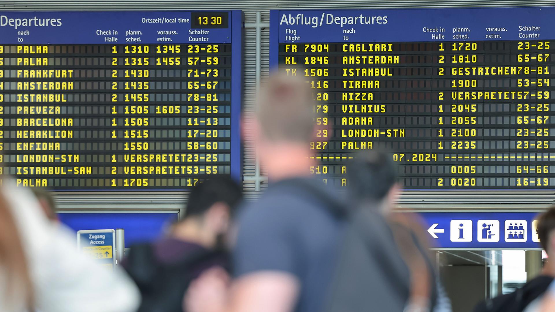 Reisende warten vor der Anzeigentafel am Nürnberger Flughafen | Daniel Löb/dpa