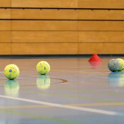 Handbälle auf einem Hallenboden. 