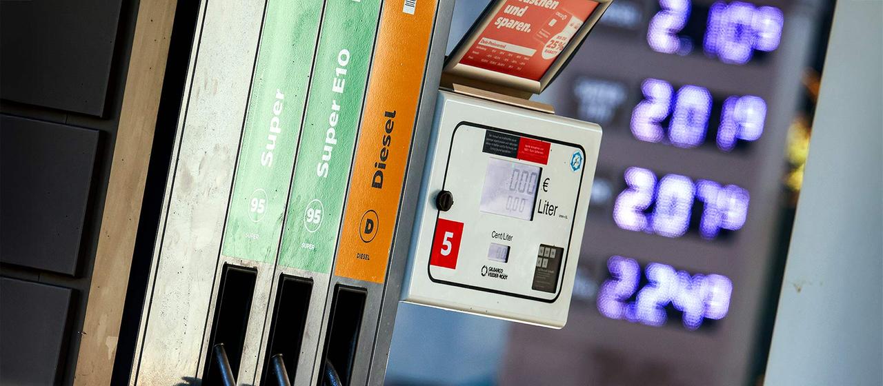 Preistafel und Zapfsäulen an einer Tankstelle.