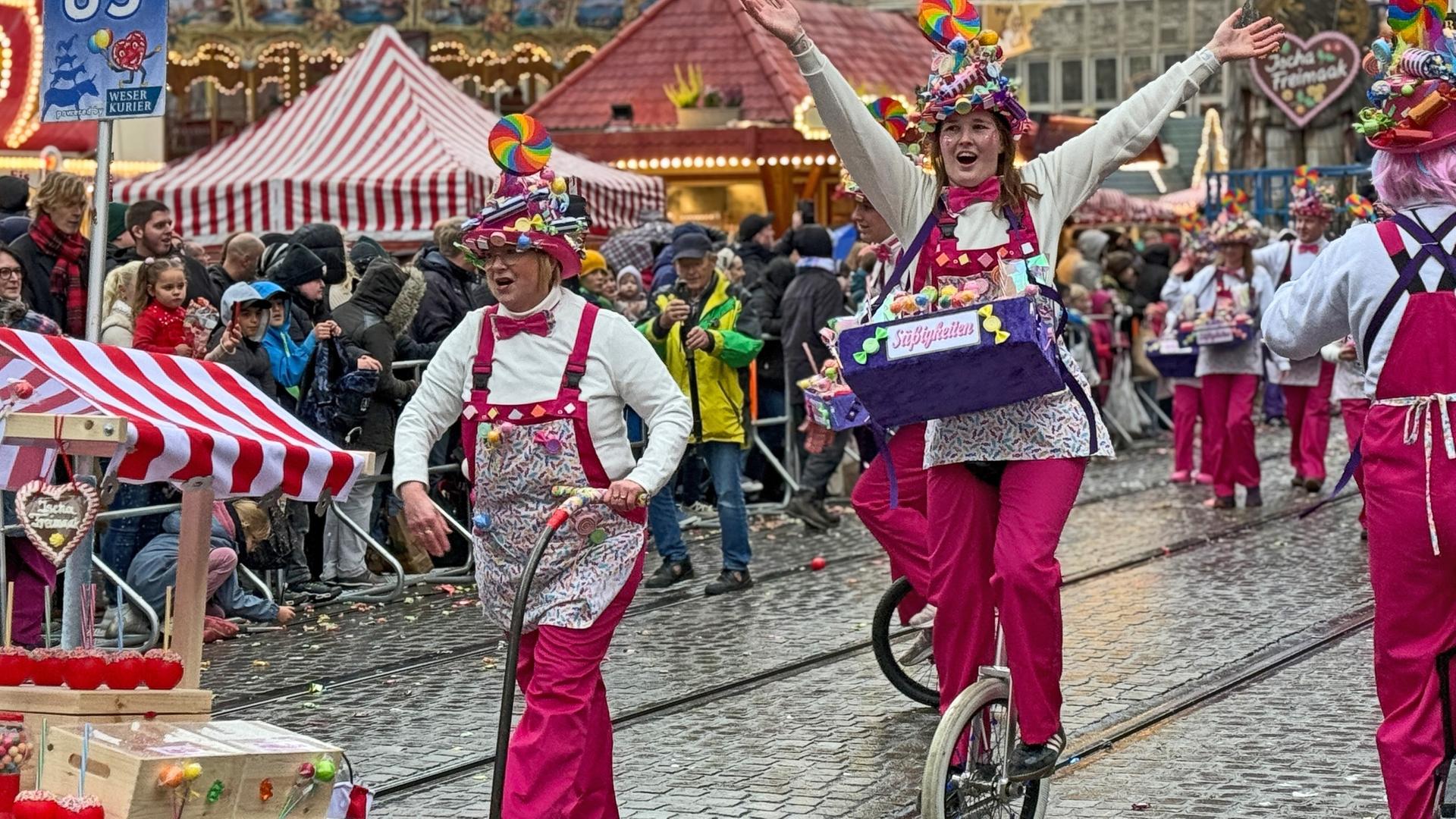 Eine Süßigkeitenverkäufer präsentieren sich auf Einrädern beim Freimarktsumzug | Radio Bremen | Inès Schumann