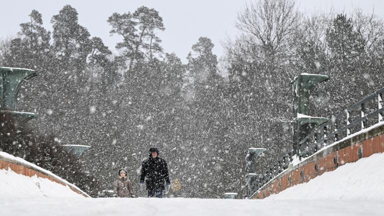 Menschen laufen durch Schnee in Stockholm, Schweden.