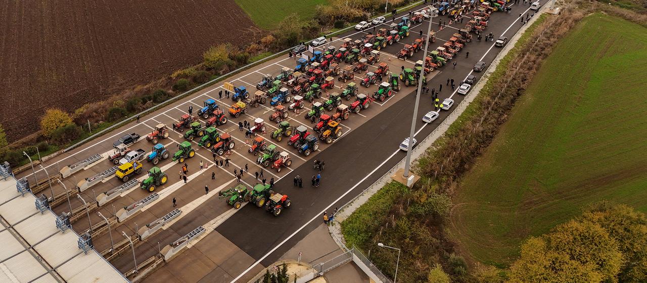 Die Drohnenaufnahme zeigt Traktoren von Landwirten, die in der Nähe von Trikala (Griechenland) eine Nationalstraße in der Nähe einer Mautstelle blockieren.