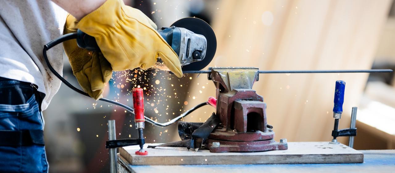 Ein Mann arbeitet in der Malzfabrik Schöneberg in einer Werkstatt für Holz- und Metallarbeiten.
