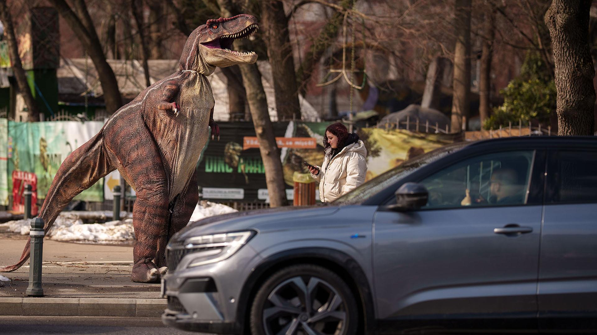 Eine Person in einem DinosaurierkostÃ¼m lÃ¤uft vor einem Dino-Park in der Innenstadt von Bukarest, RumÃ¤nien, vorbei. | AP