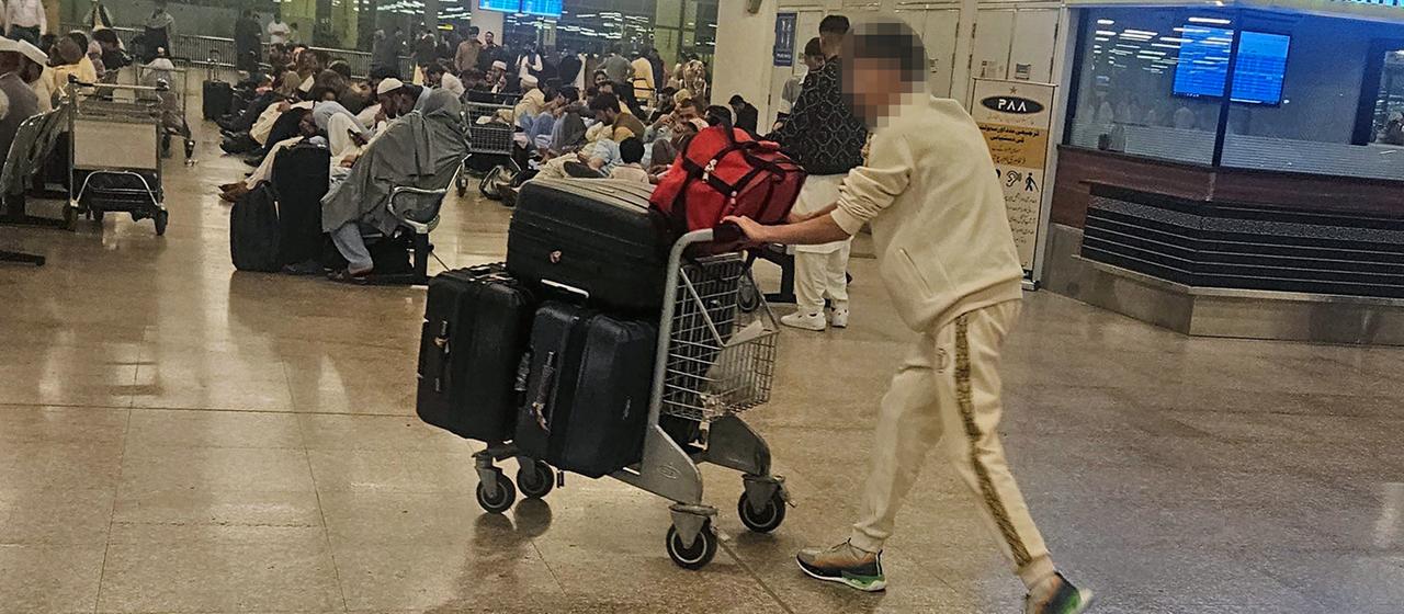 Personen mit Gepäck halten sich am Flughafen in der pakistanischen Hauptstadt Islamabad auf.