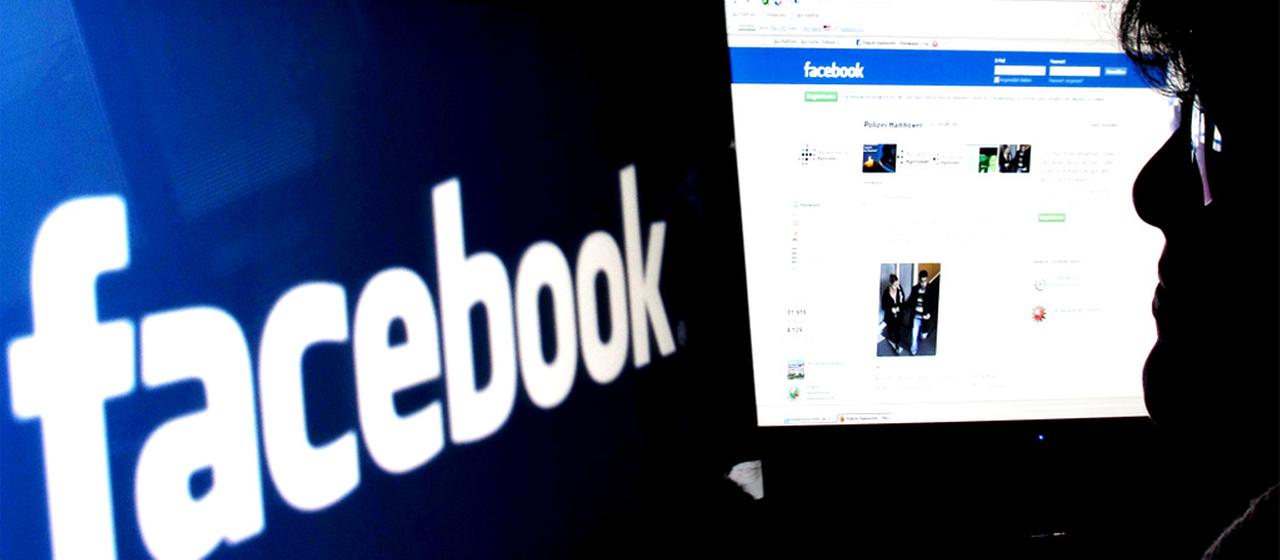 Frau sitzt vor Facebook-Acoount
