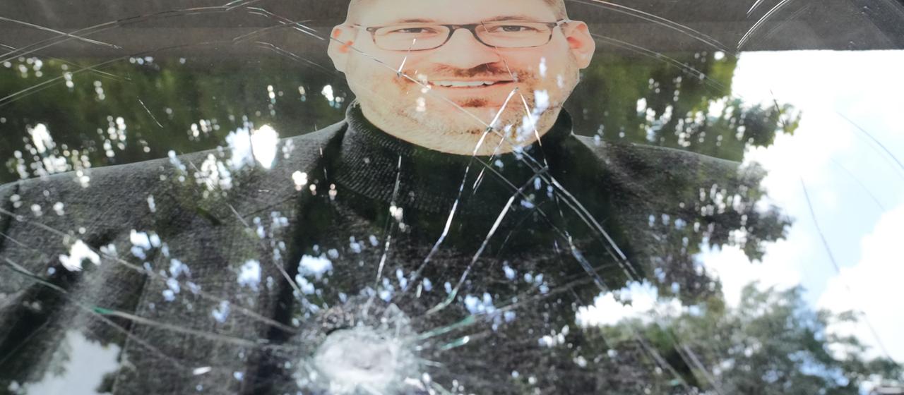 Eine Scheibe mit dem Konterfei von Lars Düsterhöft an seinem Wahlkreisbüro hat ein Einschussloch. 