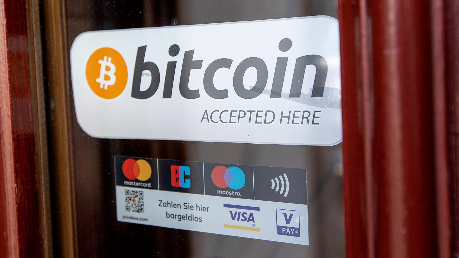 Bitcoin-Aufkleber an einer Restaurant-Türe. | picture alliance / dpa Themendie