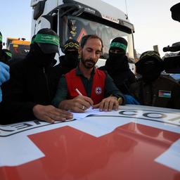  Hamas-Mitglieder übergeben die sterblichen Überreste an Mitarbeiter des Roten Kreuzes.