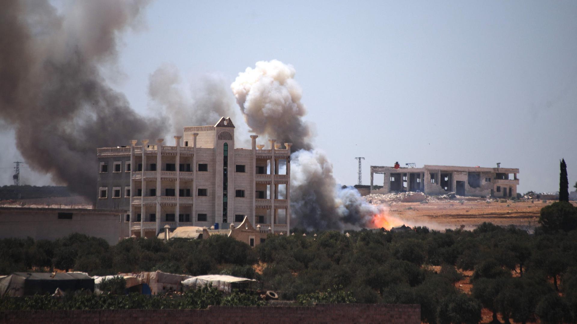 Eine Rauchwolke steigt nach einer Explosion in Maarrat Misrin im nördlichen Teil der syrischen Provinz Idlib auf. | AFP