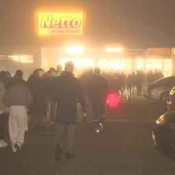 Menschen stehen Schlange vor einem Supermarkt in Kleve.