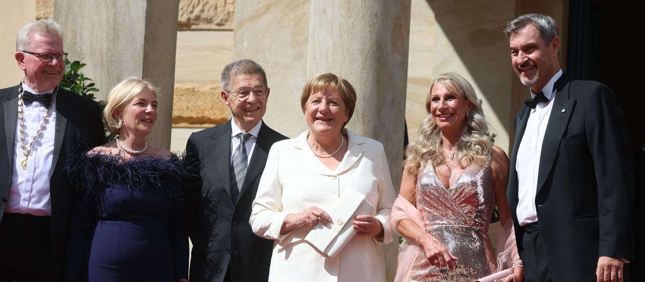 Thomas Ebersberger (CSU, l), Bürgermeister von Bayreuth und seine Frau Stefanie Hellbach, Joachim Sauer, Angela Merkel (CDU), ehemalige Bundeskanzlerin, Karin Baumüller-Söder und Markus Söder (CSU), Ministerpräsident von Bayern, kommen zur Eröffnung der Bayreuther Festspiele