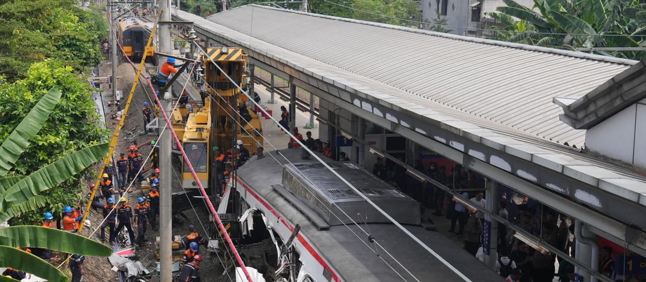 Arbeiter entfernen die Trümmer eines Zuges nach einer Kollision in Bekasi, Indonesien.