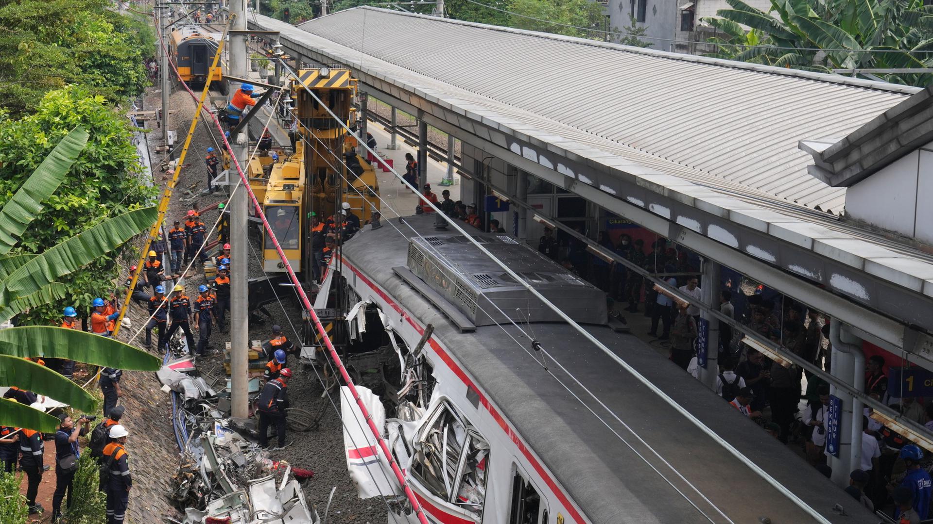 Arbeiter entfernen die Trümmer eines Zuges nach einer Kollision in Bekasi, Indonesien. | AP