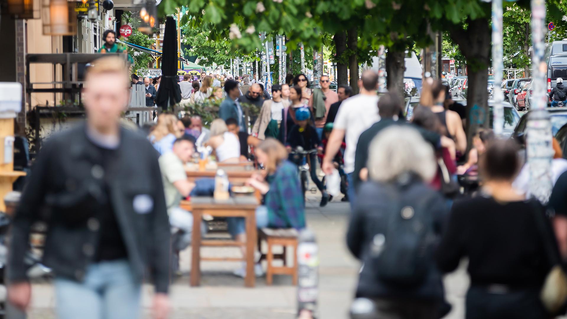 Passanten gehen im Berliner Bezirk Prenzlauer Berg an einem Restaurant vorbei. | dpa