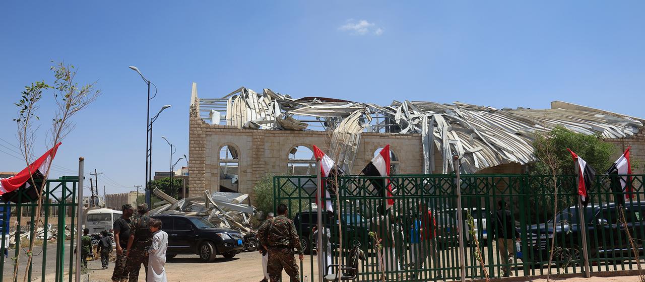 Houthi-Soldaten stehen vor einer zerstörten Sporthalle in Sanaa, Jemen.