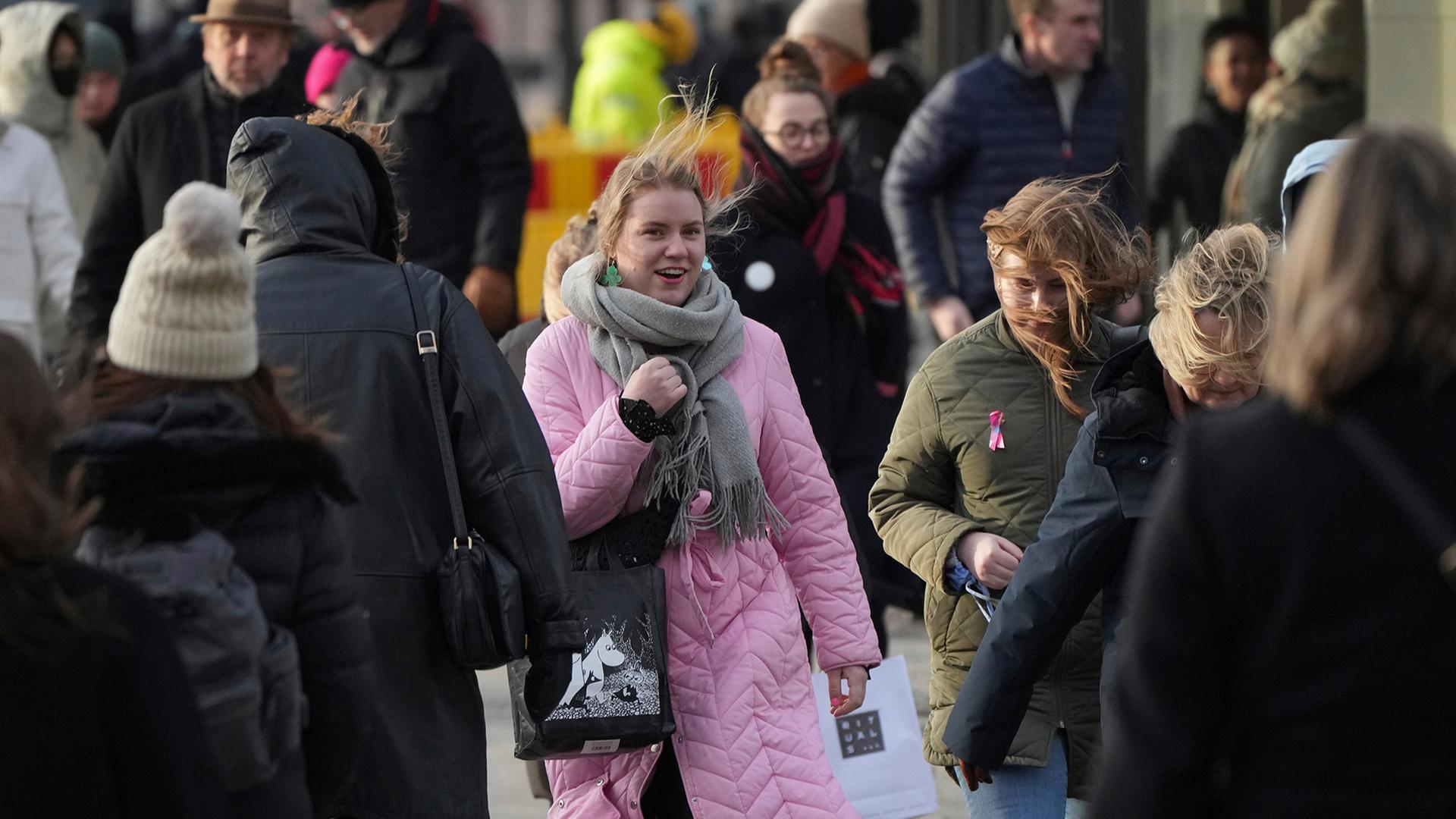 Menschen gehen eine Straße in Helsinki entlang. | AP