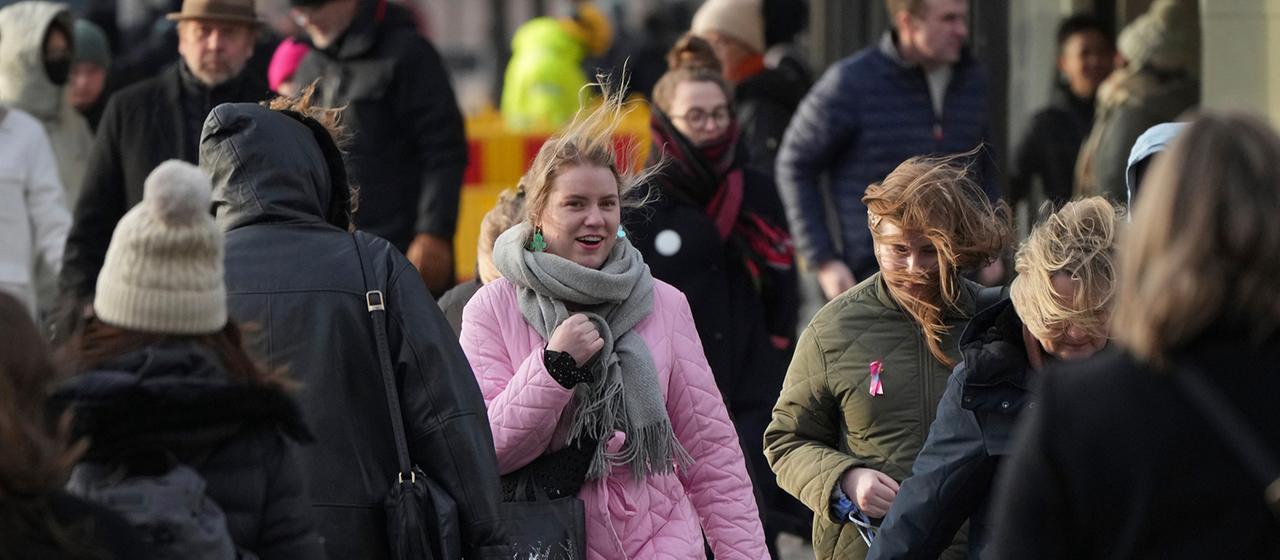 People walk down a street in Helsinki.