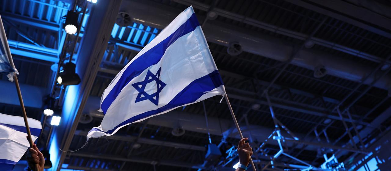 Ein Mann schwenkt nach der Parlamentswahl in Israel die Nationalflagge
