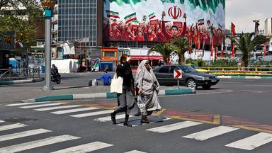 Iranische Frauen gehen in Teheran auf einer Straße spazieren.