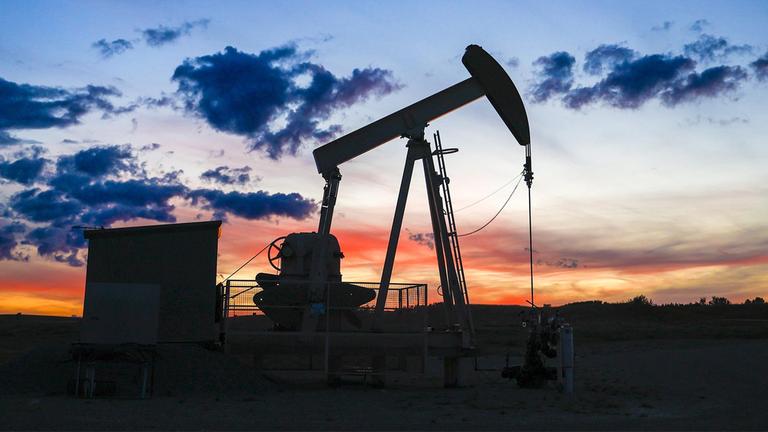 Silhouette einer Ölpumpe auf einem Ölfeld.
