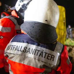 Notfallsanitäter stehen an einer Unfallstelle.