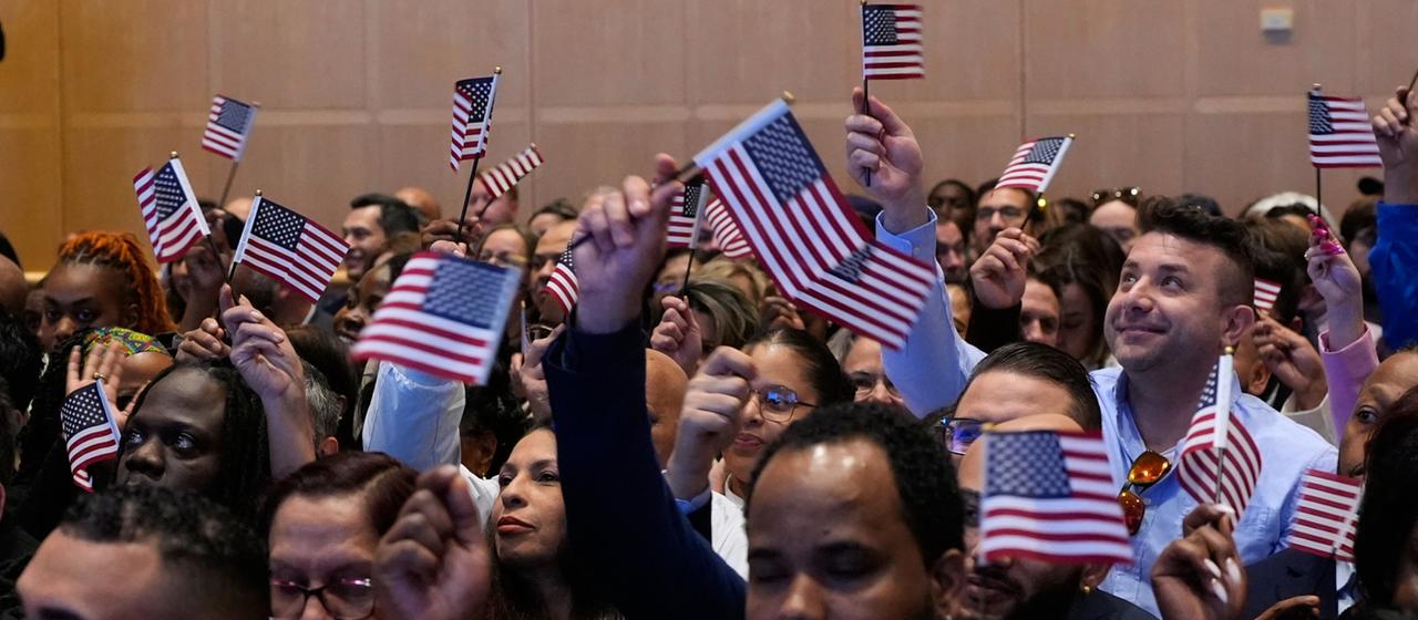 Menschen schwenken Fahnen der USA bei einer Einbürgerungsfeier