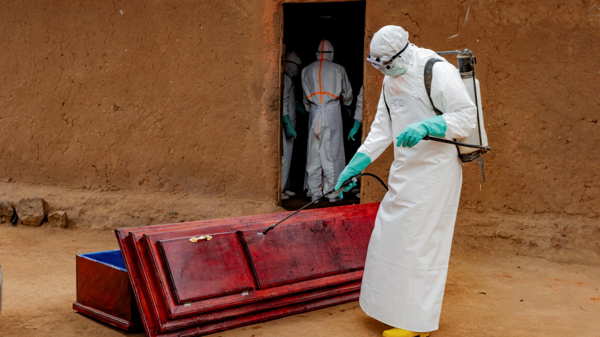Mitglieder des Zivilschutzes desinfizieren einen Sarg in Buni, DR Kongo. | REUTERS