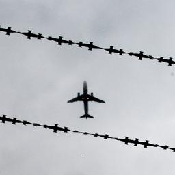 Ein Flugzeug ist hinter Stacheldraht zu sehen.