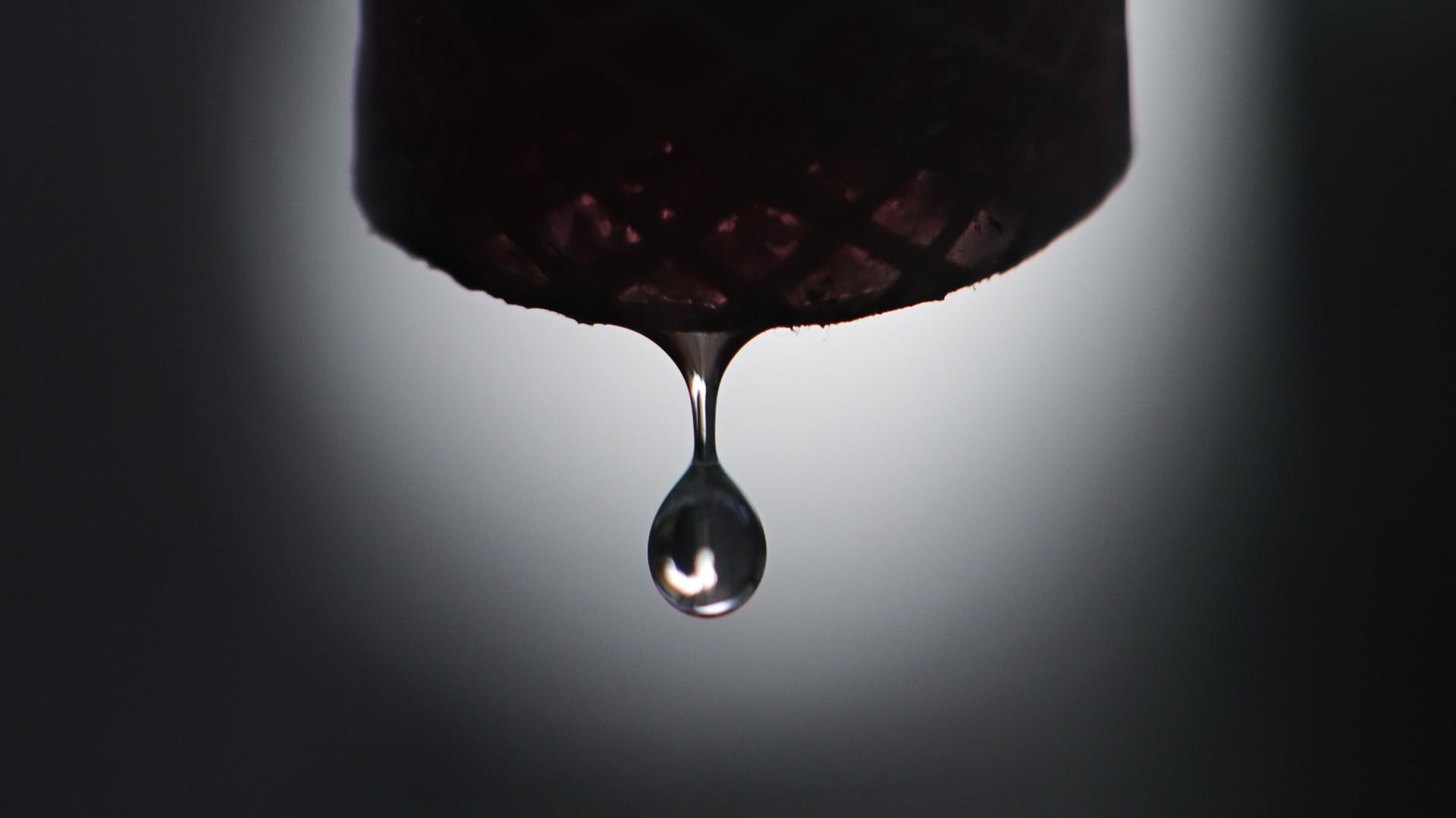 Grundwasser tropft aus einem Schlauch, der per Pumpe an einen Grundwasserbrunnnen angeschlossen ist. | dpa