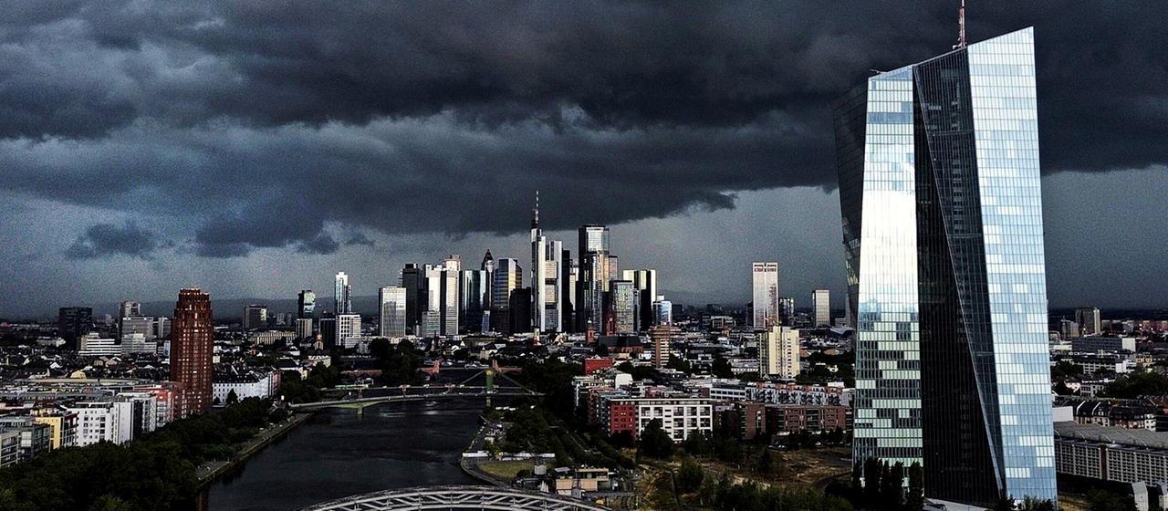 EZB und Bankenviertel in Frankfurt und dunkle Wolken über der Stadt.